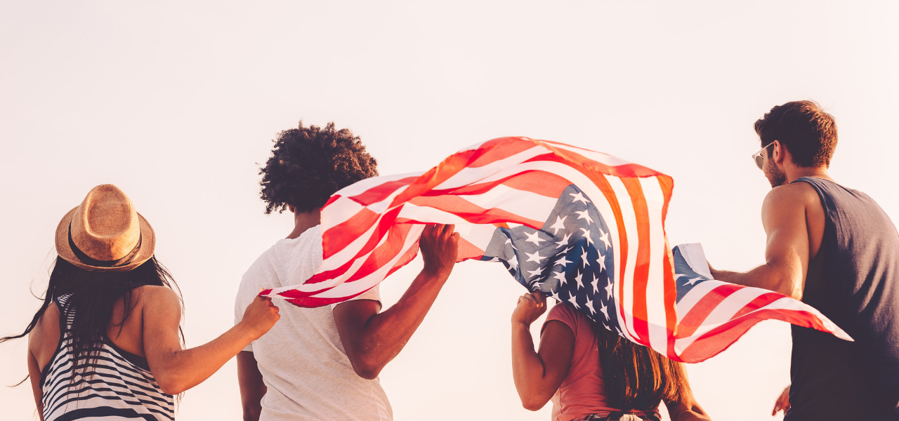 4 jóvenes sosteniendo bandera americana