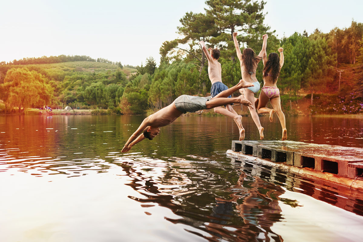 Niños saltando a lago